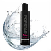 Black bottle of Popstar Play silicone-based lubricant with water splash on a white background