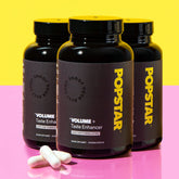 Three bottles of Popstar Volume+ Taste Enhancer on a yellow and pink gradient background.