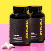 Two bottles of Popstar Volume+ Taste Enhancer on a yellow and pink background